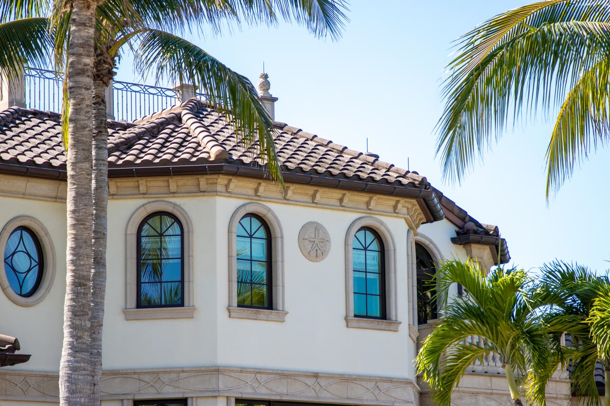 Arched impact windows on Florida home with palm trees
